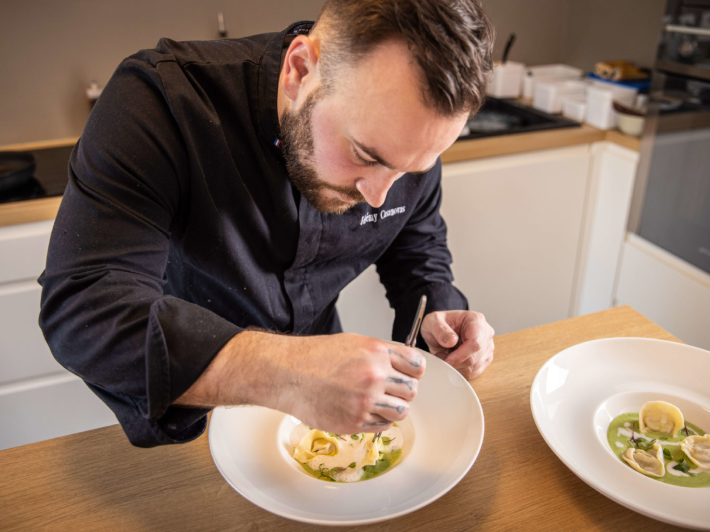 Photo où le chef prépare une assiette minutieusement